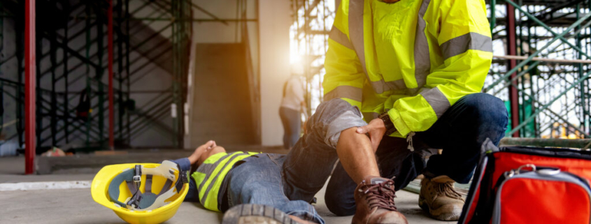 A construction worker helps his injured coworker following a workplace accident